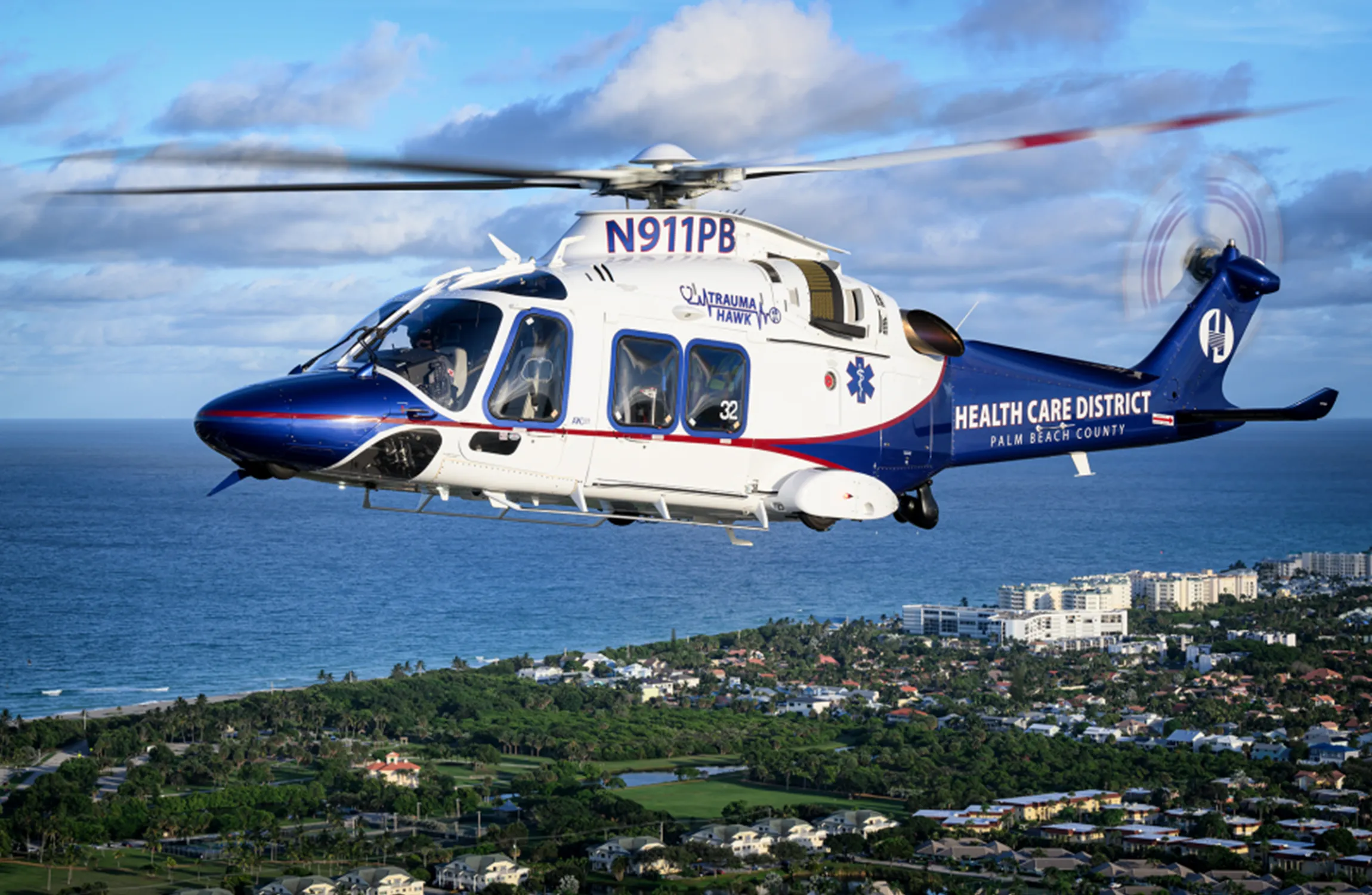 A medical helicopter flying over a coastal town