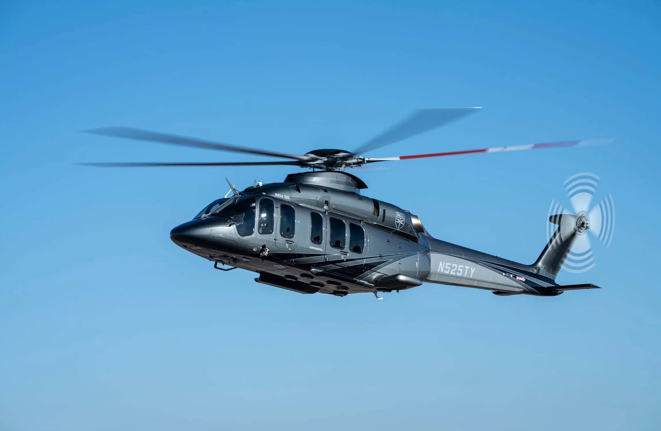 A large grey helicopter flying in the sky