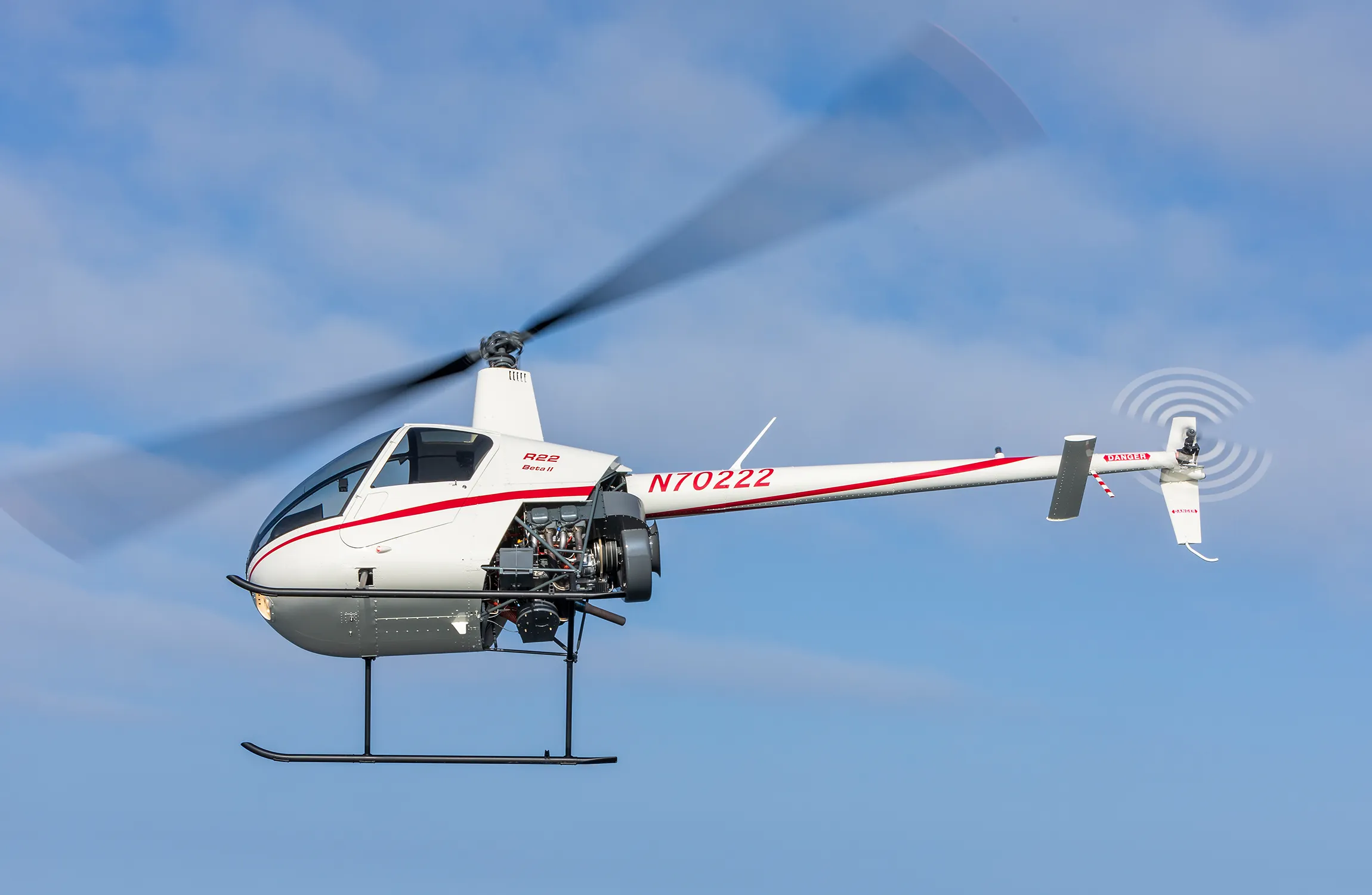 A white helicopter flying in the sky