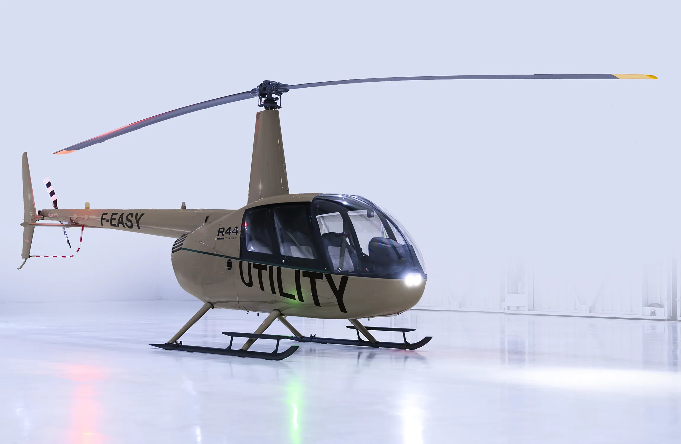 A brown helicopter in a white hangar