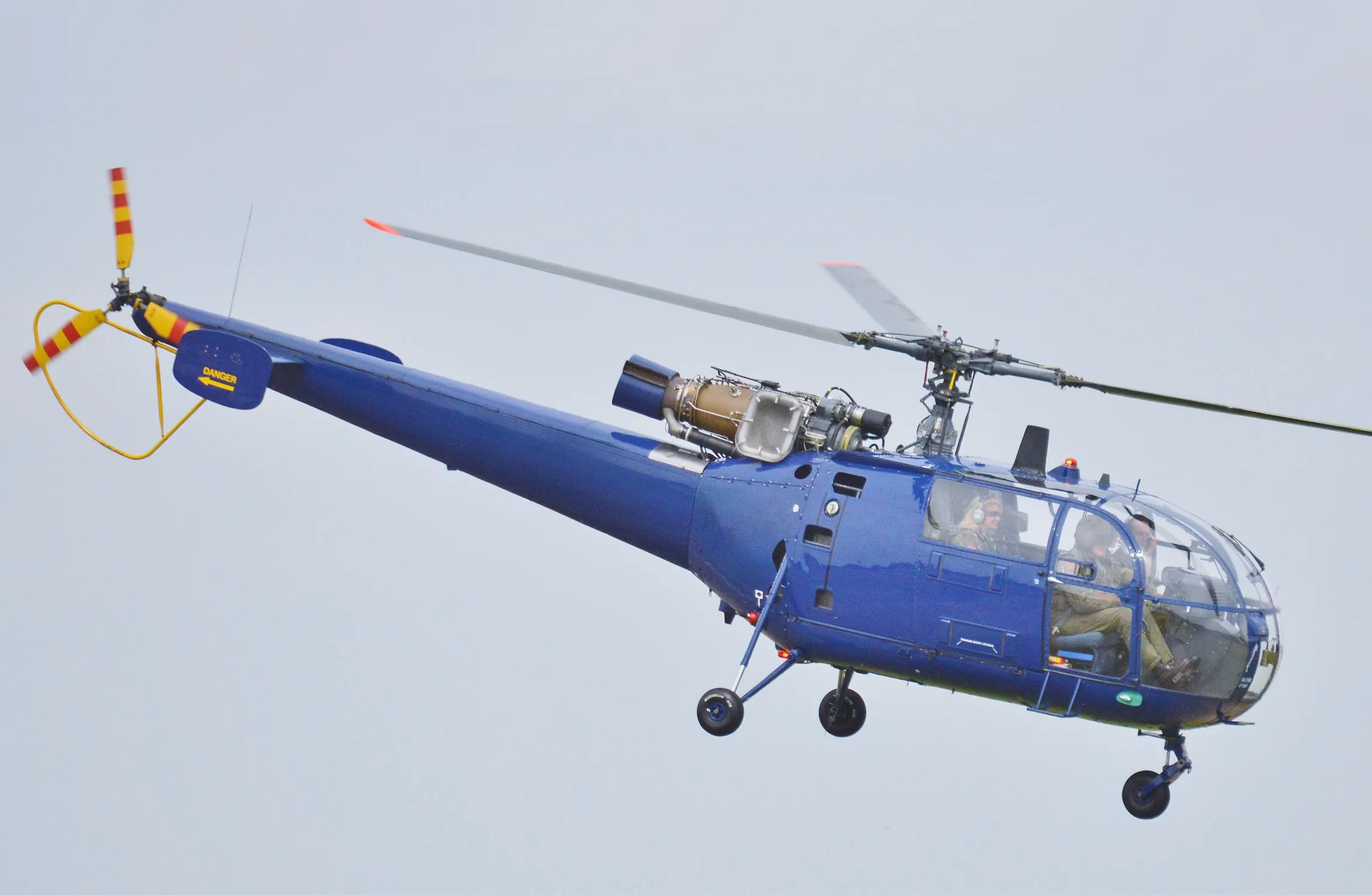 A green helicopter in a blue sky